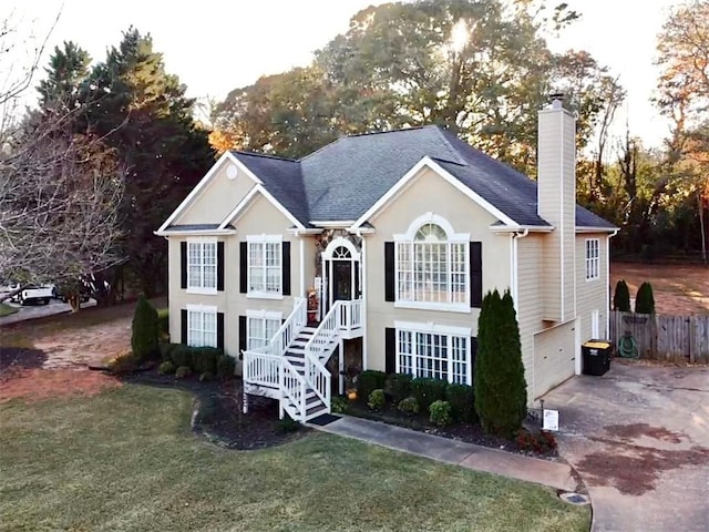 raised ranch with a garage and a front lawn