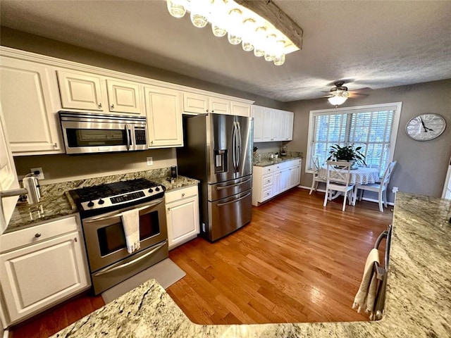 kitchen featuring white cabinetry, appliances with stainless steel finishes, dark wood-type flooring, and ceiling fan