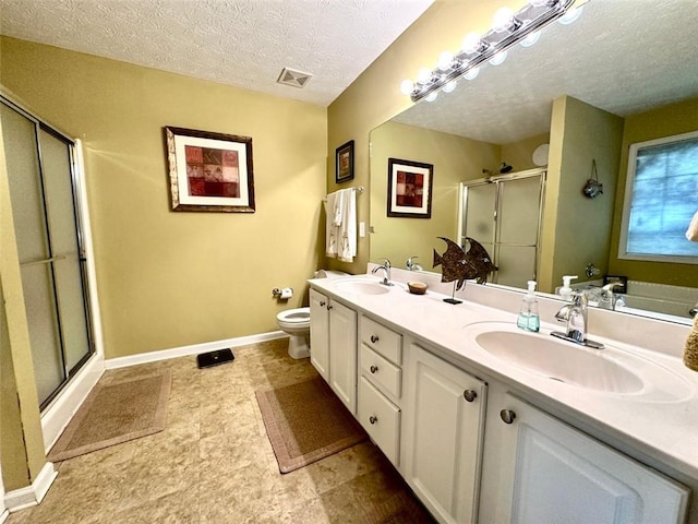 bathroom featuring toilet, vanity, a textured ceiling, and a shower with door