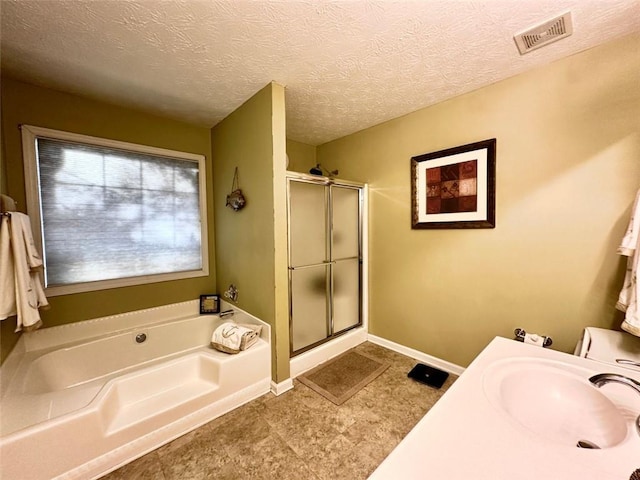 bathroom featuring independent shower and bath, a textured ceiling, and sink