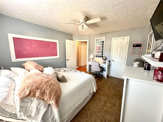 carpeted bedroom featuring a textured ceiling and ceiling fan