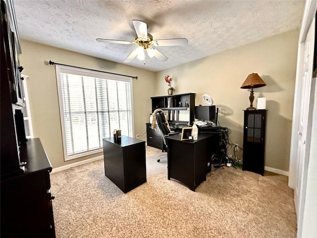 carpeted office space featuring a textured ceiling and ceiling fan