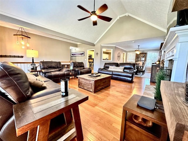 living room with ornamental molding, high vaulted ceiling, light hardwood / wood-style floors, and ceiling fan