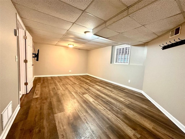 basement with a drop ceiling and wood-type flooring