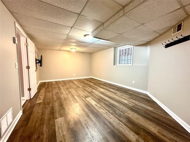 basement featuring a drop ceiling and hardwood / wood-style floors