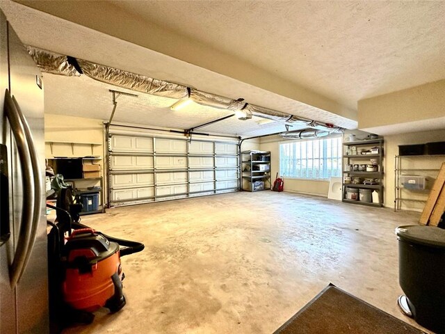 garage featuring a garage door opener and stainless steel fridge