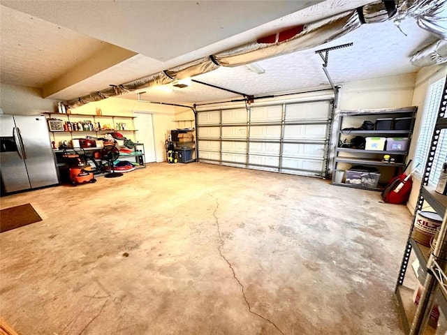 garage featuring a garage door opener and stainless steel fridge