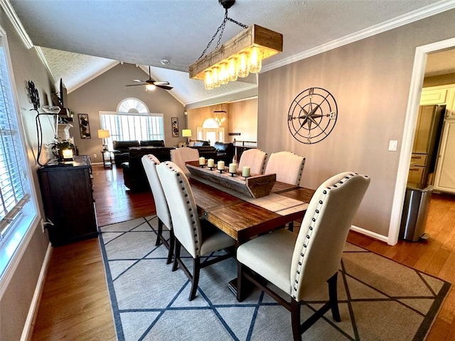 dining area featuring crown molding, a textured ceiling, dark hardwood / wood-style floors, vaulted ceiling, and ceiling fan with notable chandelier