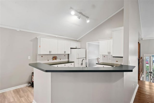 kitchen with crown molding, white cabinetry, white refrigerator, kitchen peninsula, and light hardwood / wood-style flooring