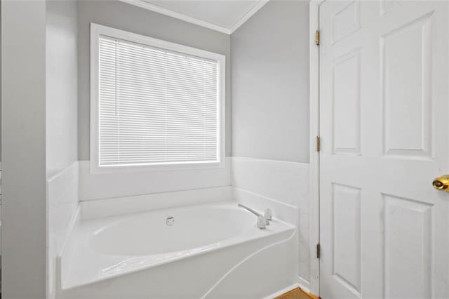 bathroom with ornamental molding and a bathing tub