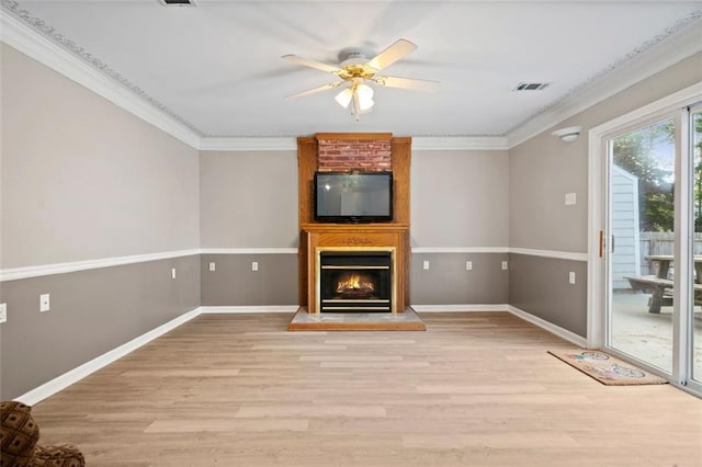 unfurnished living room featuring ornamental molding, a fireplace, light hardwood / wood-style floors, and ceiling fan