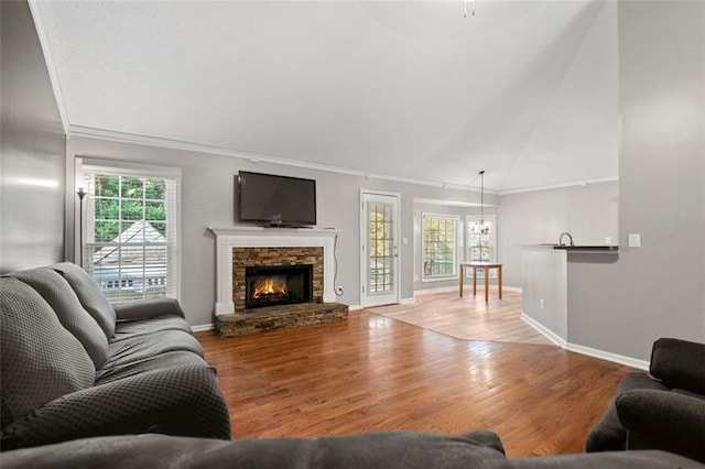 living room featuring sink, crown molding, light hardwood / wood-style floors, and a fireplace