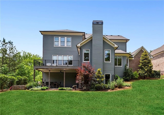 1393 Kings Park Dr NW, Kennesaw, GA 30152 - back of property with a balcony, a chimney, a yard, and a ceiling fan