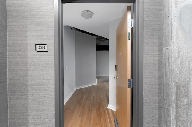 hallway with hardwood / wood-style flooring