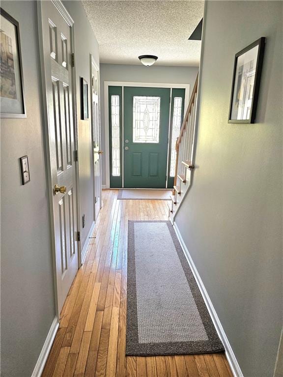 doorway with wood-type flooring and a textured ceiling