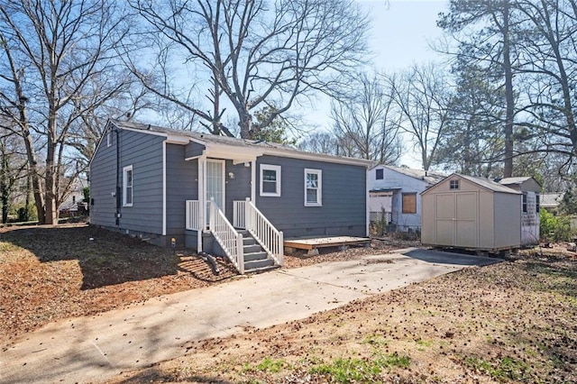 view of front of property featuring driveway, a storage unit, and an outdoor structure