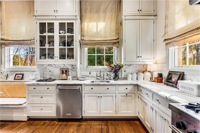 kitchen featuring a sink, light stone counters, white cabinetry, dishwasher, and dark wood-style flooring