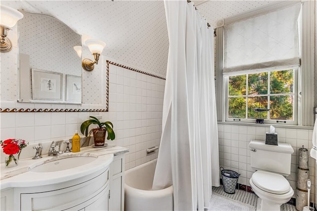 bathroom featuring toilet, vanity, wallpapered walls, and tile walls