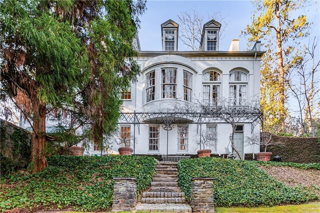 view of front of property featuring brick siding and a porch