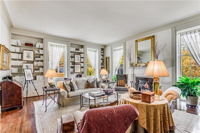 living room with wood finished floors, plenty of natural light, a fireplace, and crown molding