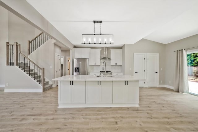 1950 Stethem Fry, Alpharetta, GA 30022 - kitchen with stainless steel fridge, wall chimney range hood, light wood-type flooring, a kitchen island with sink, and lofted ceiling