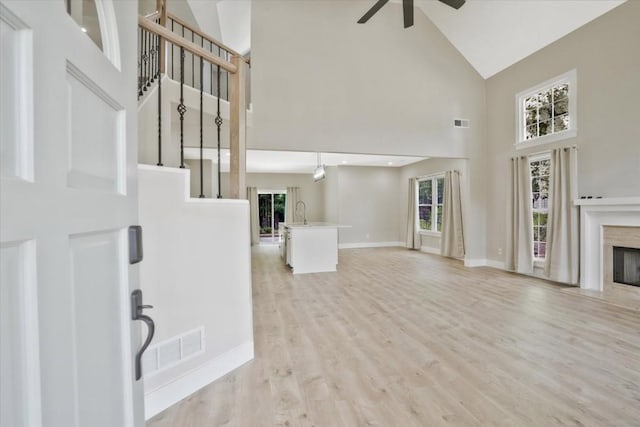 1950 Stethem Fry, Alpharetta, GA 30022 - unfurnished living room featuring high vaulted ceiling, a ceiling fan, a premium fireplace, light wood-style flooring, and stairway