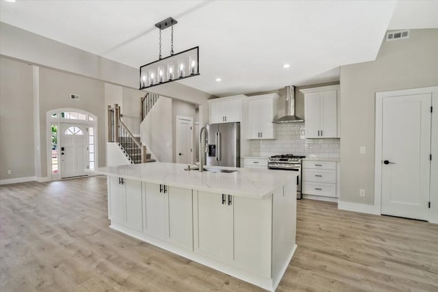 1950 Stethem Fry, Alpharetta, GA 30022 - kitchen featuring appliances with stainless steel finishes, wall chimney range hood, a kitchen island with sink, white cabinets, and tasteful backsplash