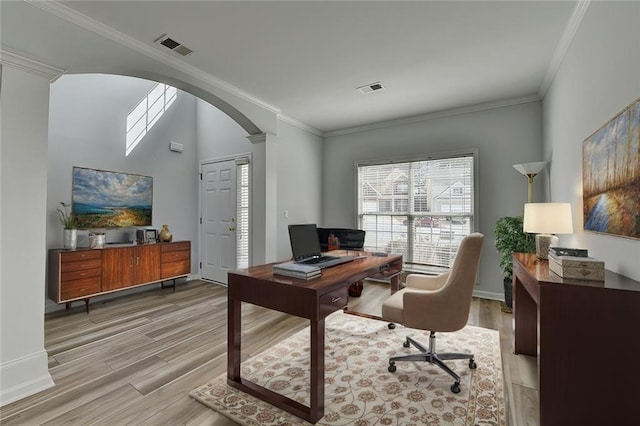 home office with arched walkways, ornamental molding, and light wood-type flooring