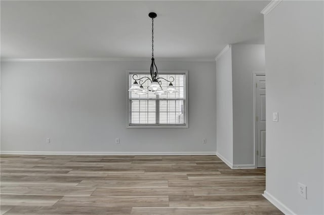 unfurnished dining area with baseboards, light wood-type flooring, a chandelier, and crown molding