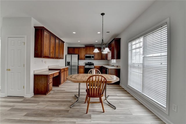 kitchen featuring a notable chandelier, stainless steel appliances, recessed lighting, light countertops, and light wood-type flooring