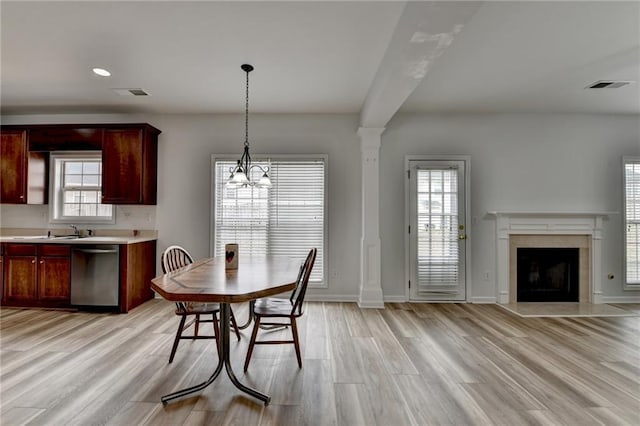 dining room with a healthy amount of sunlight, light wood-style floors, and visible vents