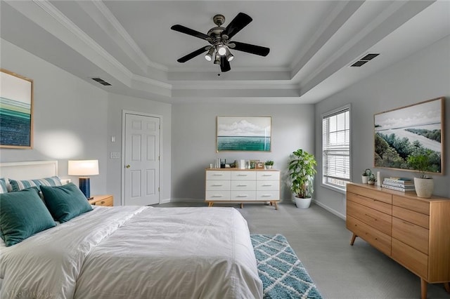 bedroom featuring visible vents, a tray ceiling, and ornamental molding