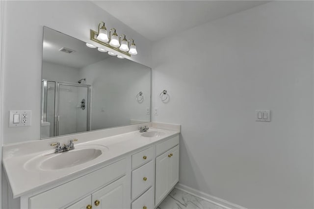 full bath featuring marble finish floor, double vanity, a stall shower, and a sink