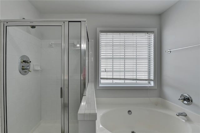 full bathroom featuring a stall shower and a garden tub