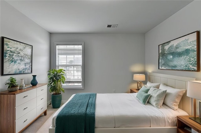 bedroom featuring visible vents and light carpet