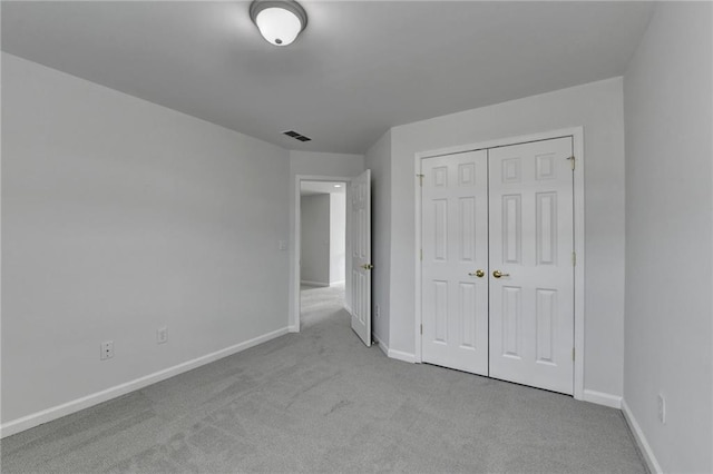 unfurnished bedroom featuring carpet, a closet, visible vents, and baseboards