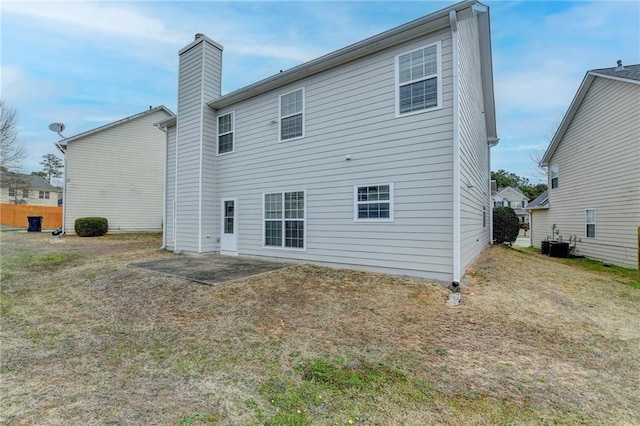 back of property featuring a patio area, a chimney, and central AC unit