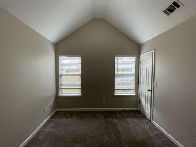 carpeted spare room with lofted ceiling