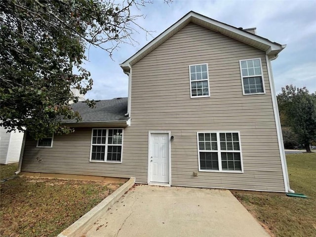 rear view of house with a patio and a lawn