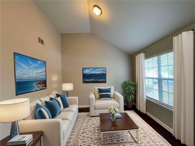 living room featuring lofted ceiling and hardwood / wood-style flooring