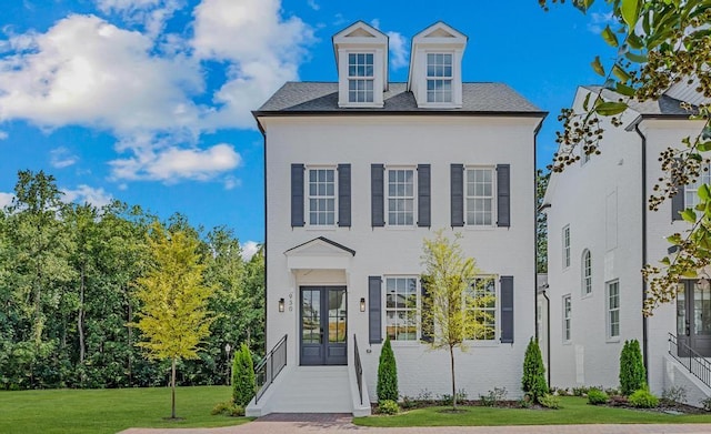 view of front of house featuring a front yard and french doors