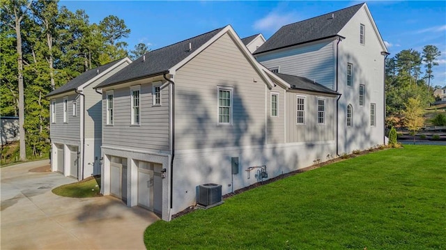 view of side of home featuring a lawn, central air condition unit, and a garage