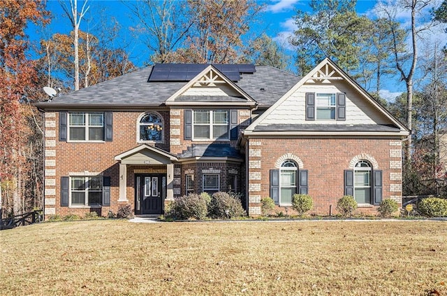 view of front facade with a front lawn and solar panels