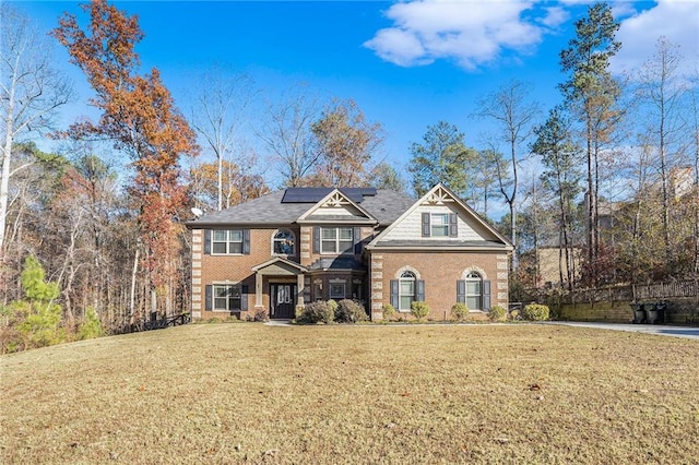 craftsman-style home with a front yard and solar panels