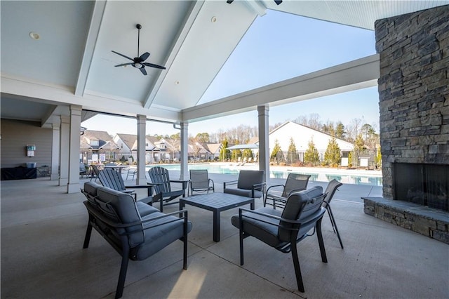 view of patio featuring ceiling fan and an outdoor stone fireplace