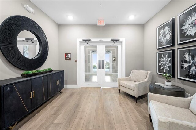 sitting room featuring french doors and light wood-type flooring