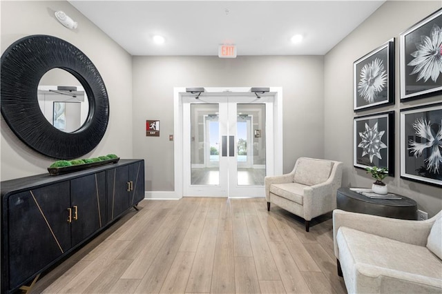 living area with french doors and light wood-type flooring