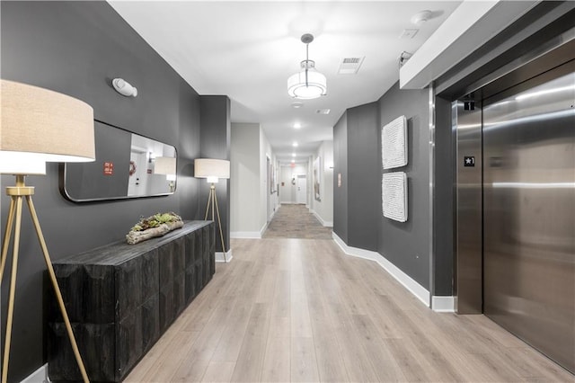 hall featuring elevator and light wood-type flooring