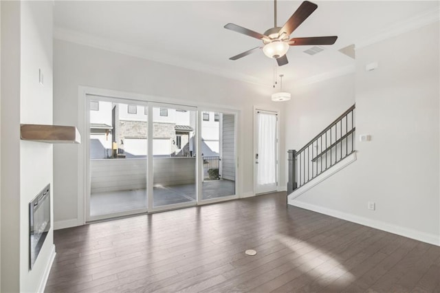671 Stickley Oak Way, Woodstock, GA 30189 - unfurnished living room with dark wood-style flooring, ornamental molding, a ceiling fan, stairway, and baseboards