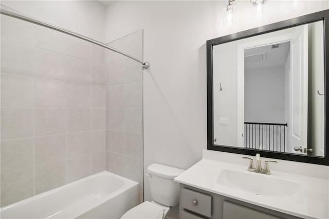 full bathroom featuring tiled shower / bath combo, toilet, and vanity